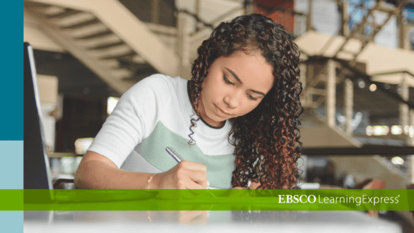 Student writing in a notebook while studying at a library table with EBSCO LearningExpress branding visible