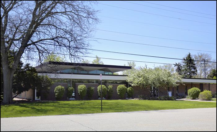 xterior of the carl sandburg library branch with modern roofline trees and landscaped lawn in front